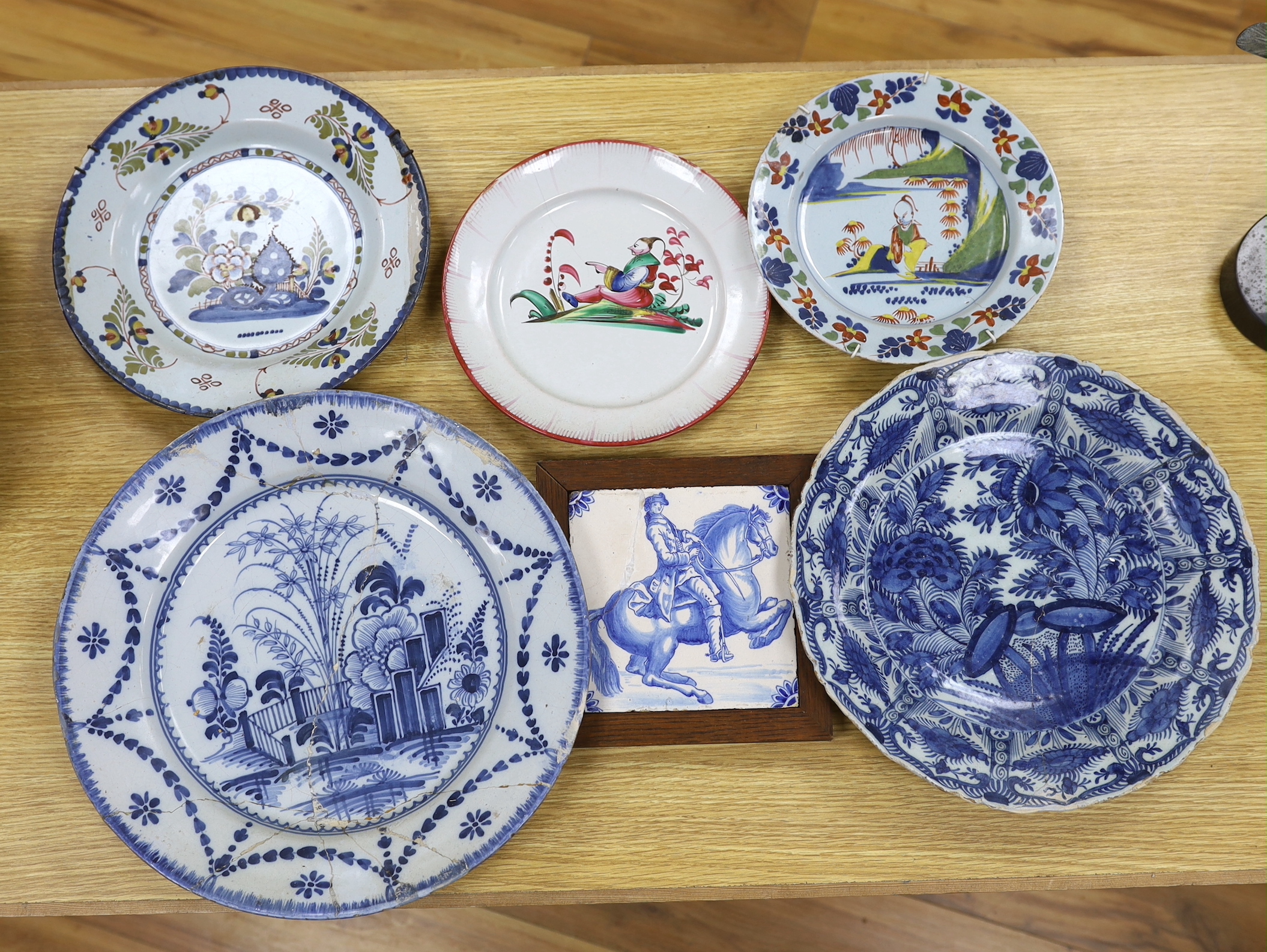 Two 18th century Delft blue and white dishes, a Delft polychrome dish, an English delftware plate, a Delft equestrian tile and a French faience plate, a.f., largest diameter 35cm